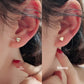 Mini heart gold stud earring at an angle showing the warm gold tone and faceted cut