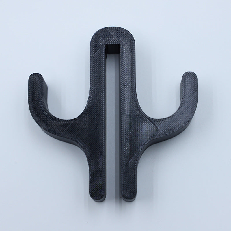 Black resin double hook with an arm on each side, seen from the front on a light background