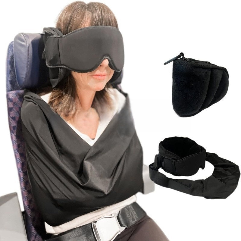 Woman on a plane seat wearing a black contoured eye mask and head support with a fabric sling, pillow and mask beside her