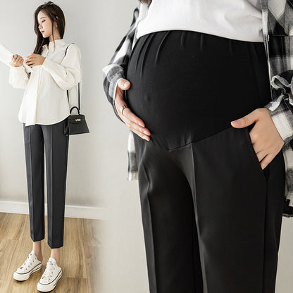 Black maternity cropped trousers on a model with a close view of the high belly panel