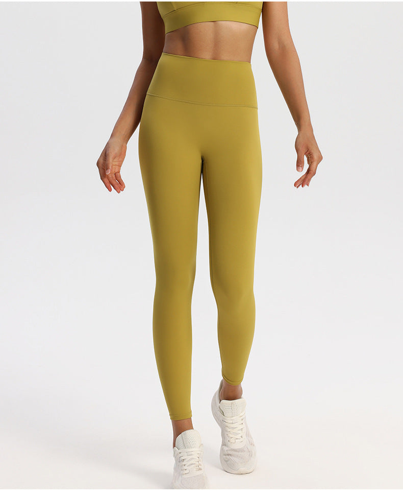 High-waisted stretch yoga leggings for women paired with white sneakers in studio