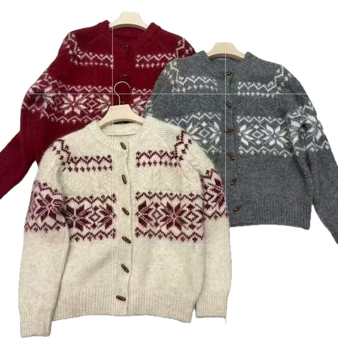 Three Fair Isle snowflake button front cardigans on hangers in wine red, gray and off-white