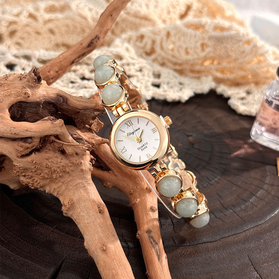 Tiger eye stone beaded quartz watch shown at an angle on a dark wood surface