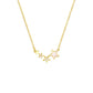 Gold and silver star necklaces draped on a cream plate near a candle