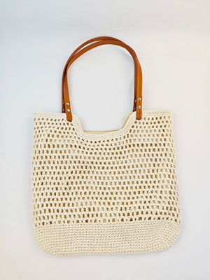 Woven cotton tote bag in beige carried on the shoulder