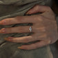 Silver open band cubic zirconia ring on a white background, side view showing the slim shank and clustered stones