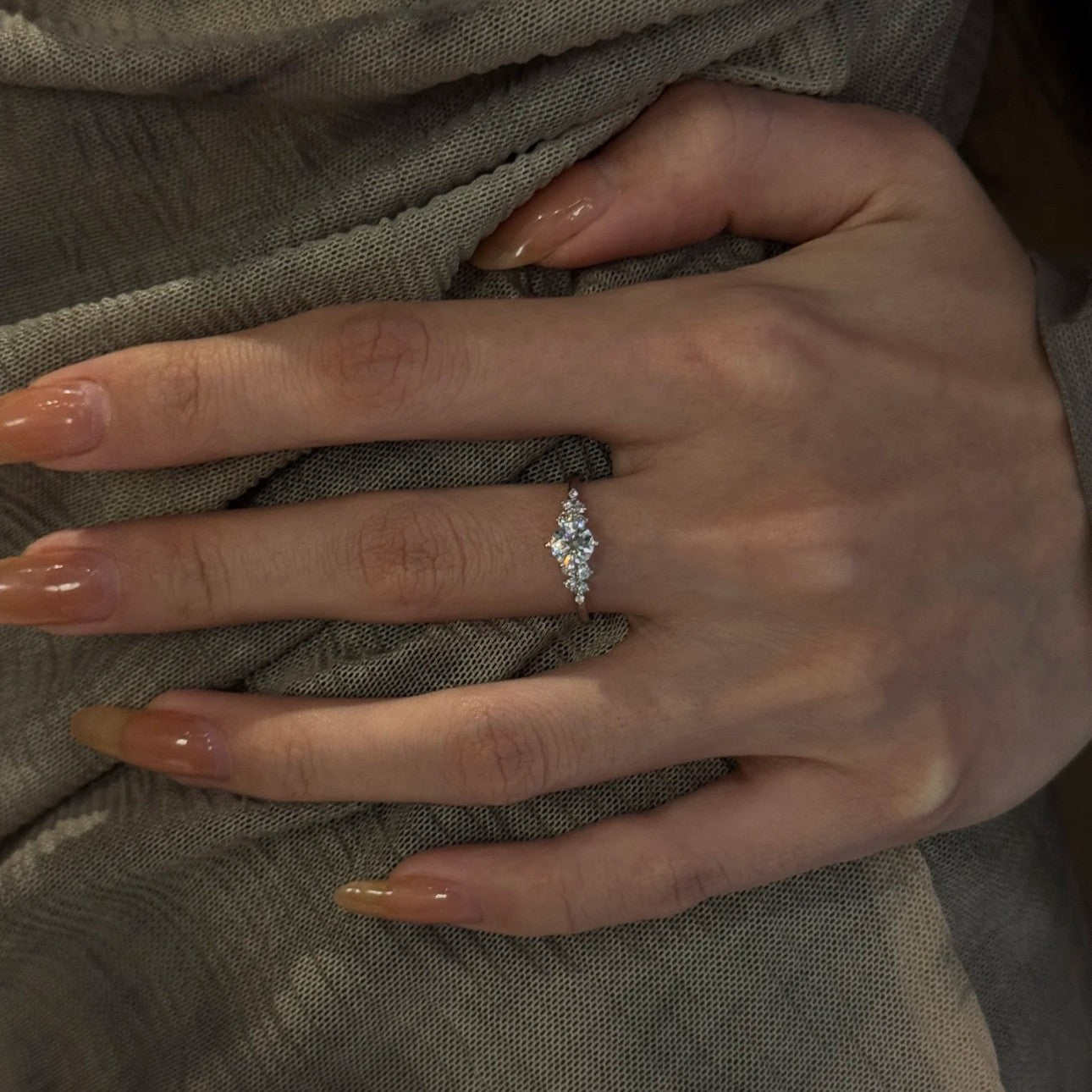 Silver open band cubic zirconia ring on a white background, side view showing the slim shank and clustered stones