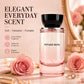 Voyage Nova perfume bottle on a marble surface between two pink roses and a gold framed mirror