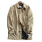 Khaki mid-length coat laid flat on a white background, single-breasted round buttons and button cuff tab