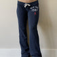 Navy low-rise flared sweatpants with drawstring waist and New York 1987 print worn front