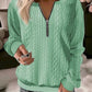 Womens cable knit quarter zip pullover styled as a light autumn layer