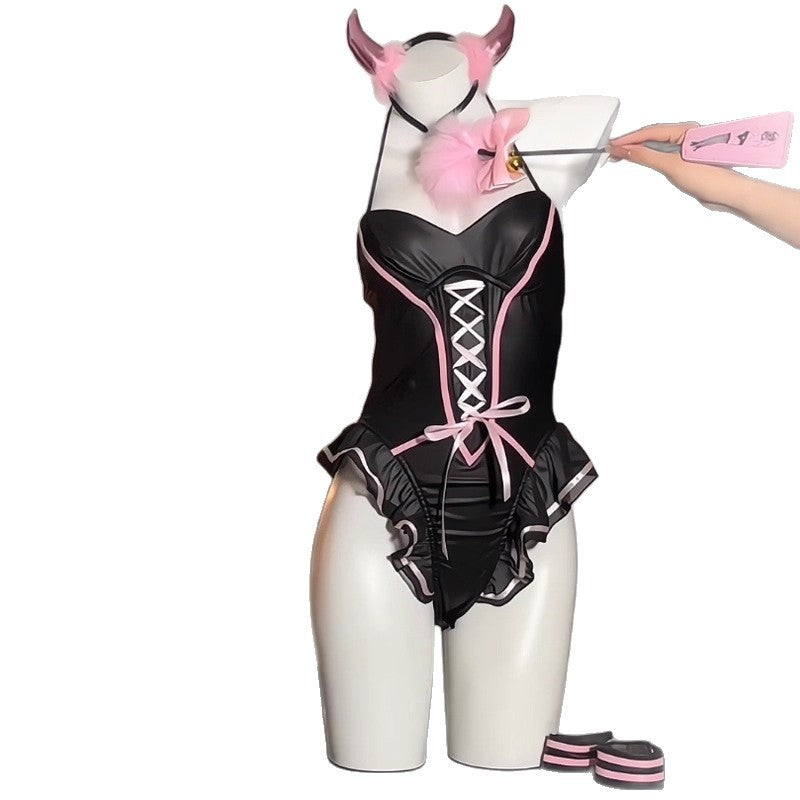 Black and pink one piece costume on a white background with a pink horn headband, a paddle and striped cuffs
