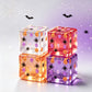 Halloween glitter squishy cube held up showing pumpkins skulls and black spiders inside