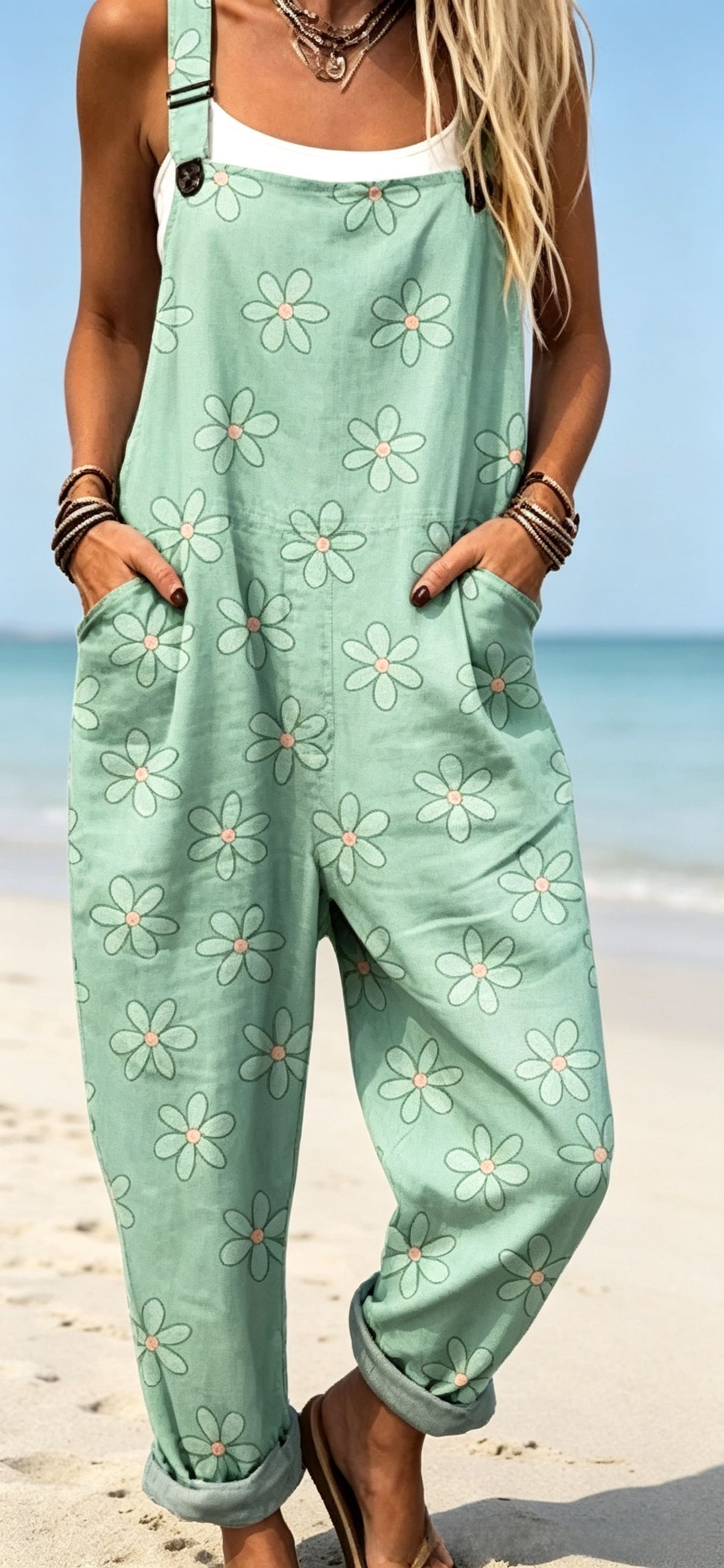 Size L option: Mint green overalls with a white daisy print, cuffed legs and pockets on a beach
