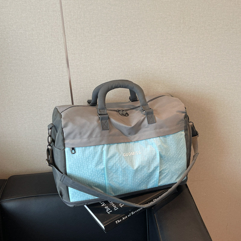 Gray and light blue travel duffel with a grid front pocket and an adjustable strap