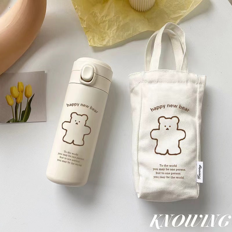 Cream bottle beside its matching canvas carry sleeve, both printed with the same brown bear drawing