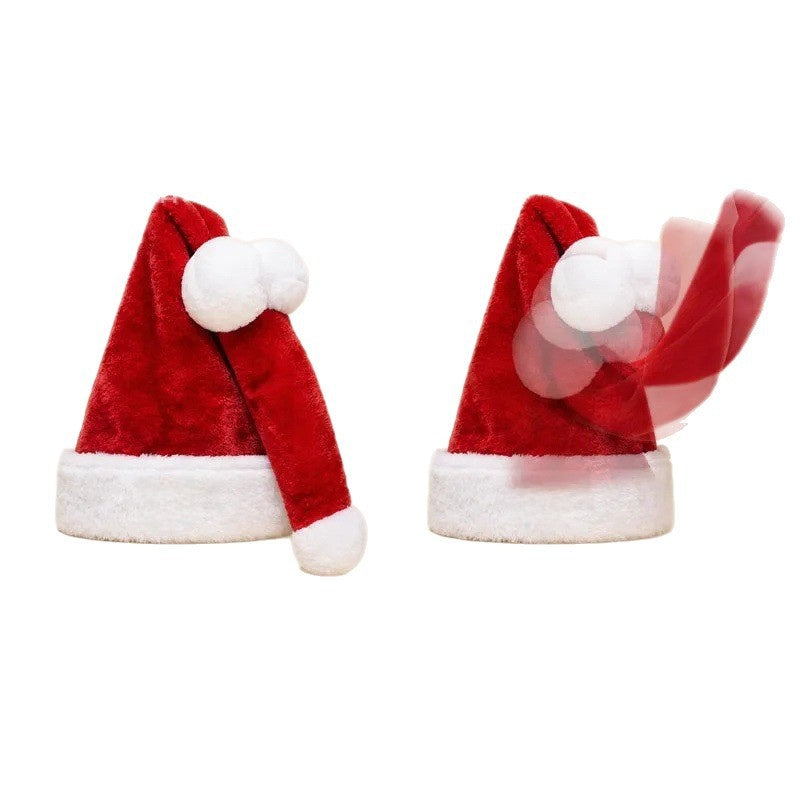 Two red plush Santa hats on white, one at rest and one with its tail swinging in a motion blur
