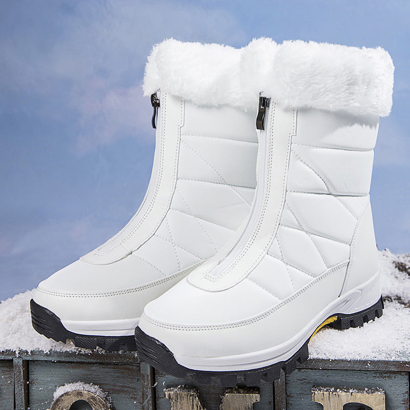 Pair of white quilted snow boots with plush fur cuffs posed on a wooden box outdoors