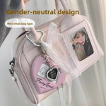 Pink glossy crossbody bag with two top handles and a photo card framed in its clear front window