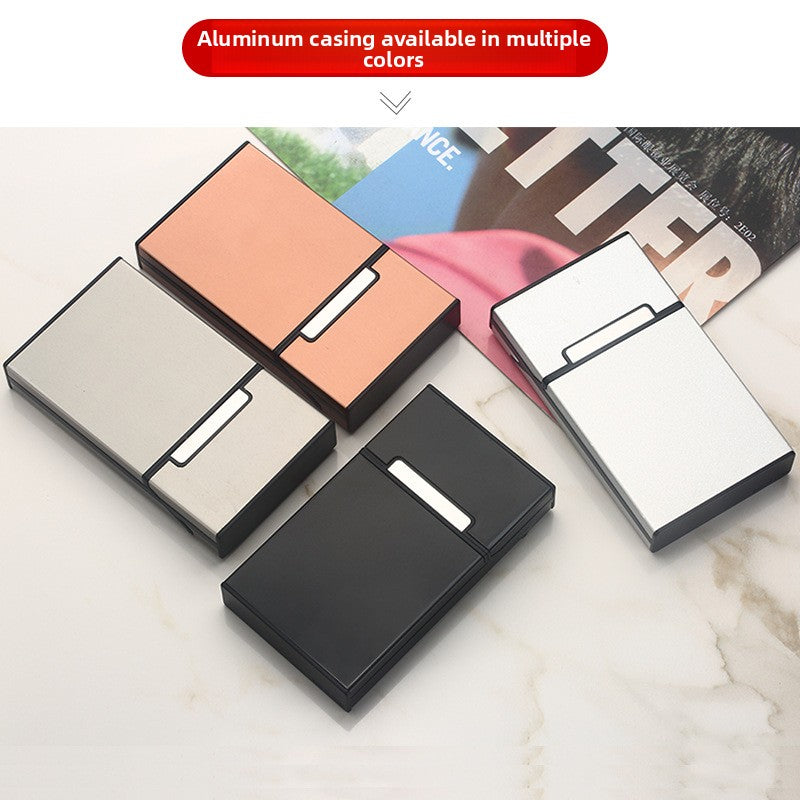 Aluminum cigarette cases in orange, silver, black, and white finishes on marble