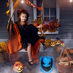 Child at a Halloween porch with a blue candy bucket glowing a pumpkin face in the dark
