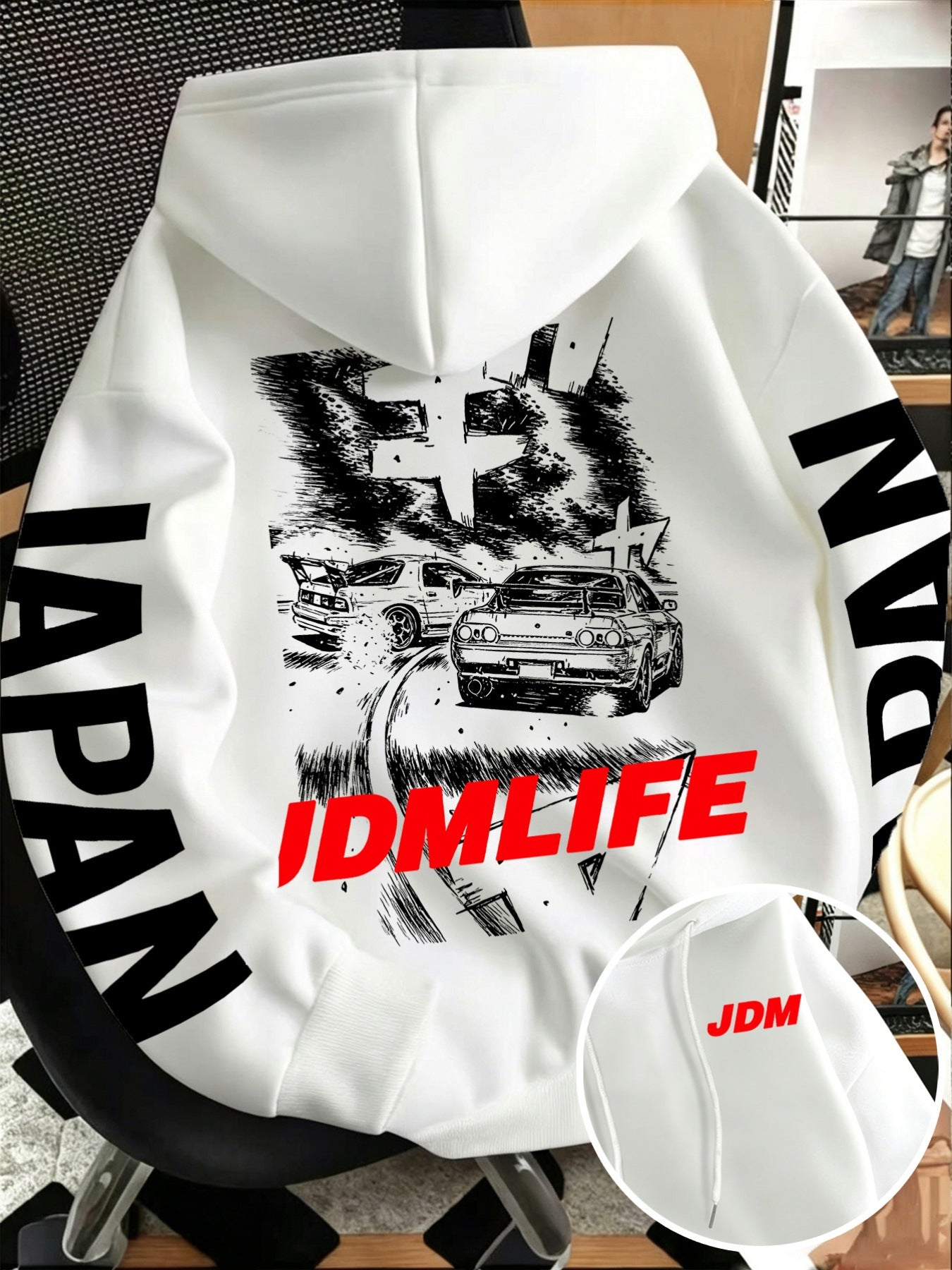 Front pocket detail of the JDM hoodie with a small red JDM tag beside the pouch pocket