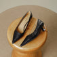 Pair of black pointed toe pumps with a low flared heel on a wooden stool, Black option, size 40