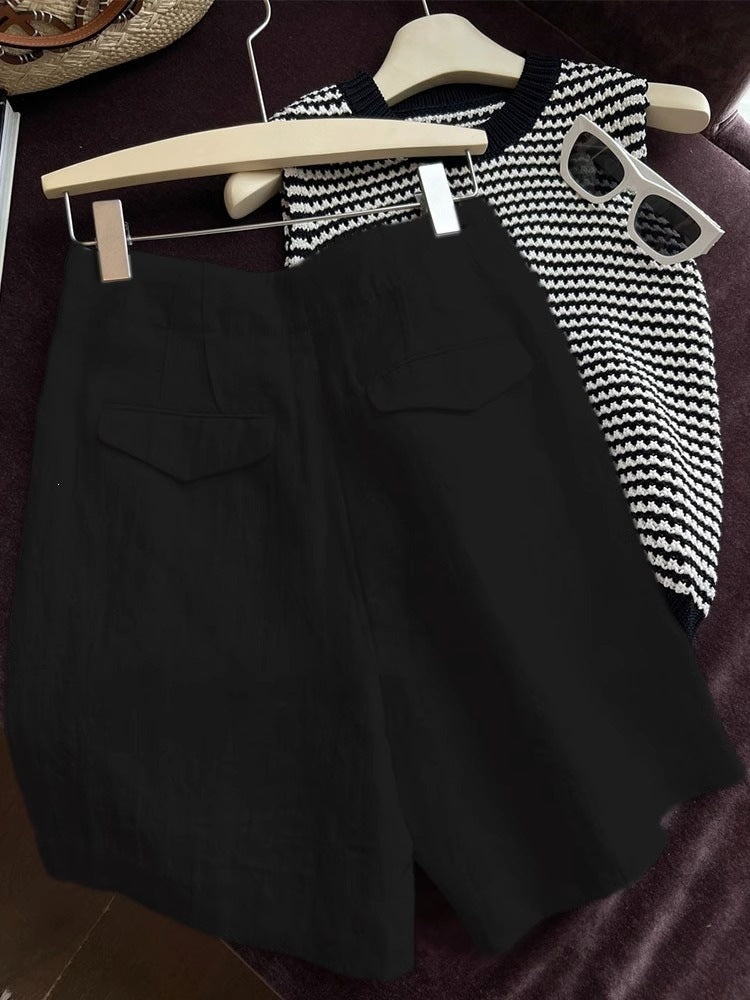 Black high waist linen shorts styled with knit top sunglasses and straw hat