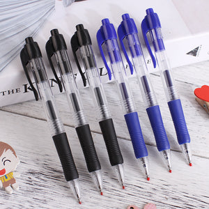 Row of black and blue retractable gel pens with rubber grips on a wooden desk
