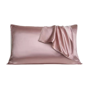 Pink silk pillowcase on a bed pillow with the envelope opening flap turned back