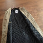 Open khaki coat on a hanger showing the black diamond quilted polyester lining and the inner front edge