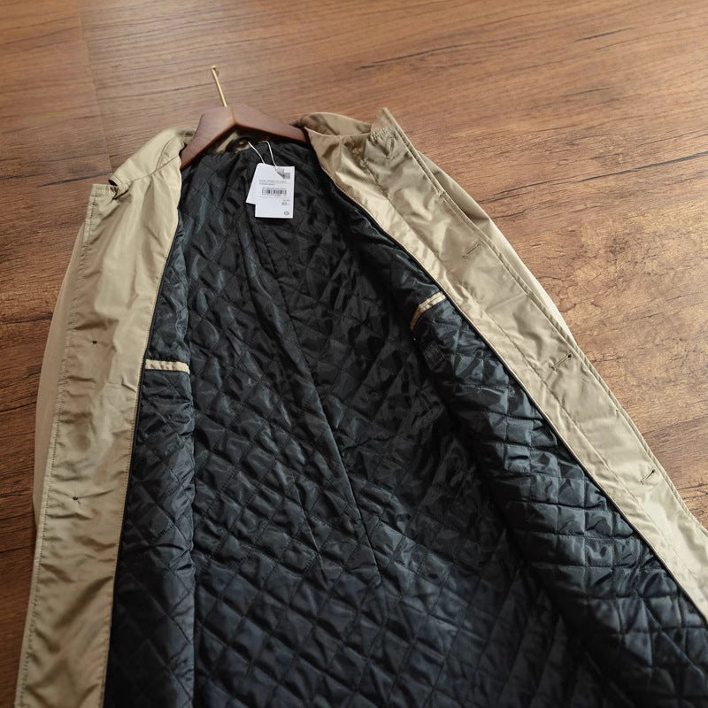 Open khaki coat on a hanger showing the black diamond quilted polyester lining and the inner front edge