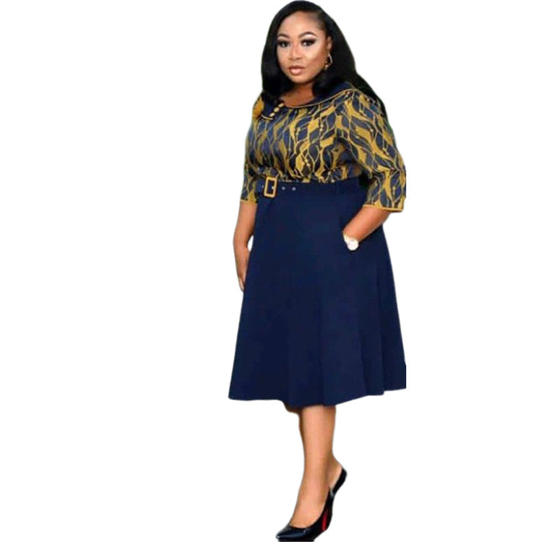 Yellow and navy belted midi dress with printed bodice and navy pleated swing skirt on a model