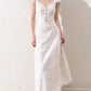 Macro close up of the patchwork lace inserts set into the cream white woven dress fabric