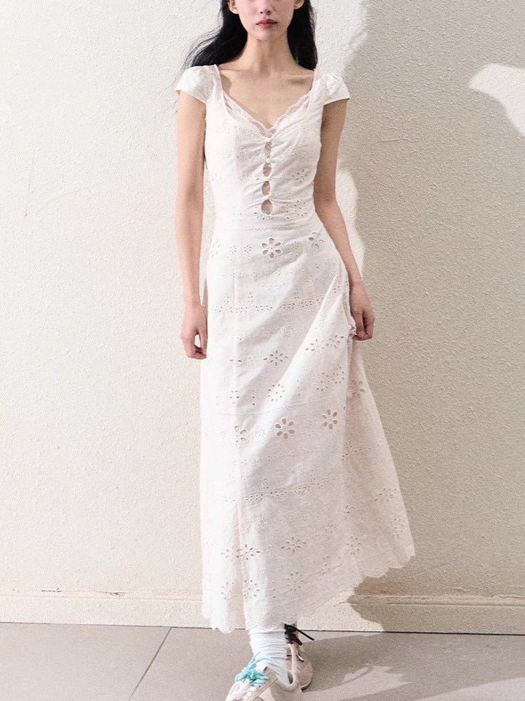 Macro close up of the patchwork lace inserts set into the cream white woven dress fabric
