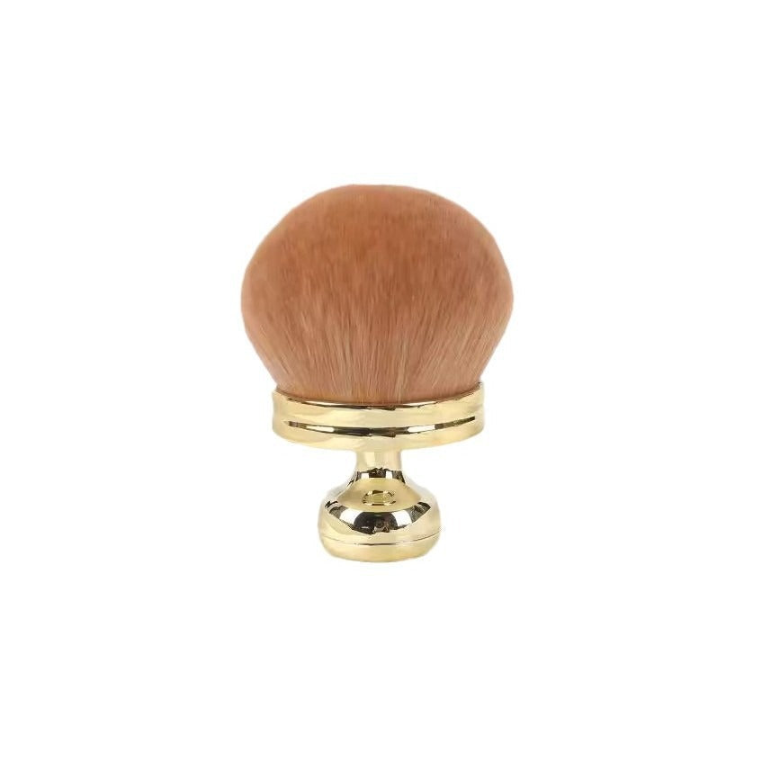 Gold handle mushroom brush with brown bristles standing upright on white
