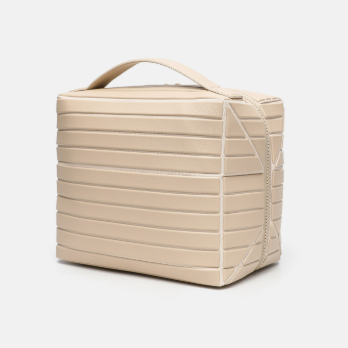 Ribbed stripe makeup organizer bag with a top handle and wrap around zip on a plain background
