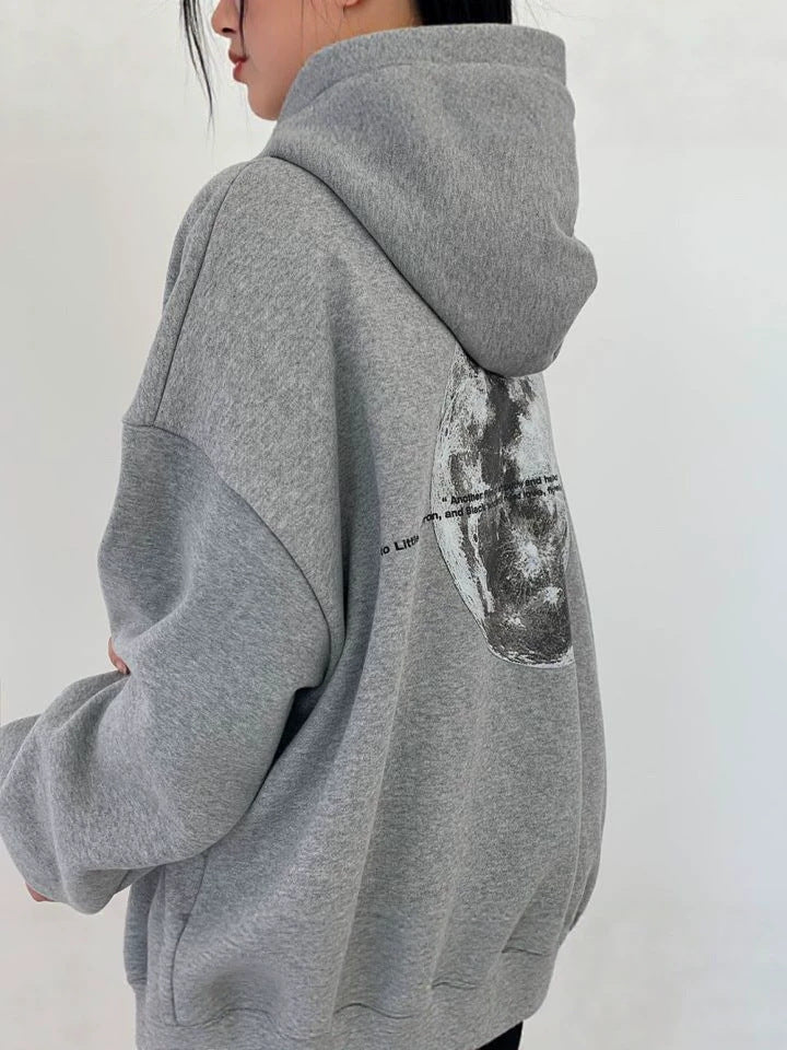 Light gray oversized hooded sweatshirt seen from the side and back with a large grayscale moon print
