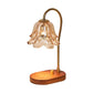 Retro candle warmer lamp with amber tulip shade and wood base with a dimmer knob on a white background