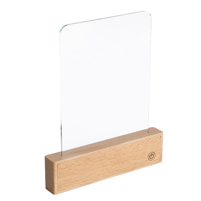 Flat panel LED reading lamp on a beech wood base lighting a magazine on a desk