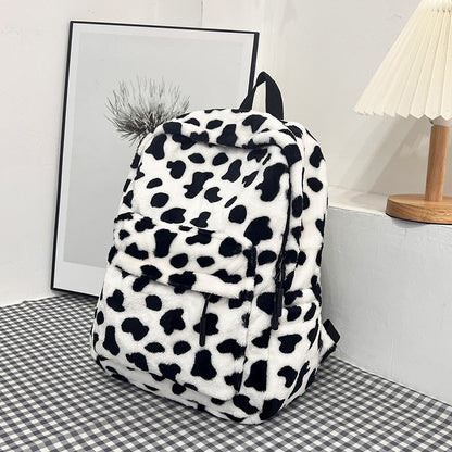Plush leopard backpack shown styled in a soft home setting with decor