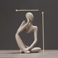 Abstract resin meditator figurine seated in thought as a minimalist shelf and desk accent