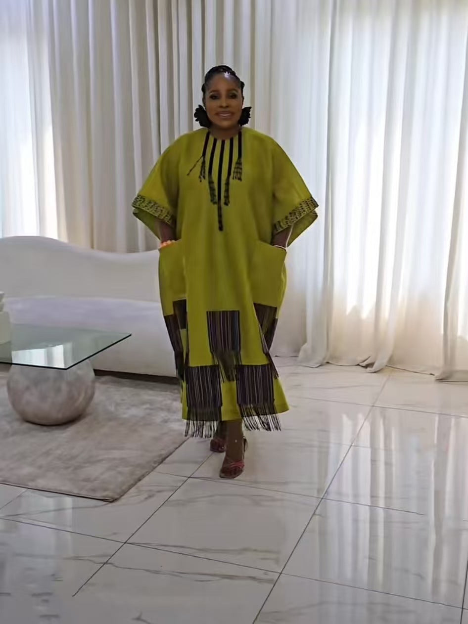 Chartreuse boubou kaftan dress of the same fringed color block design shown full length in a bright room