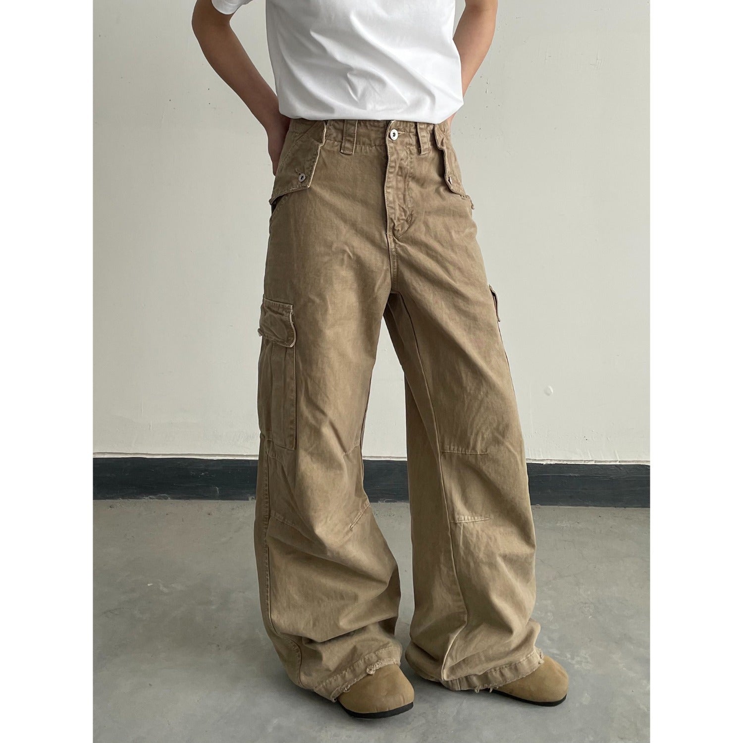 Khaki distressed loose-fit pants shown from the side, straight relaxed leg
