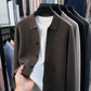 Coffee brown knit men's cardigan with turn-down collar, three buttons and patch pocket over a white tee