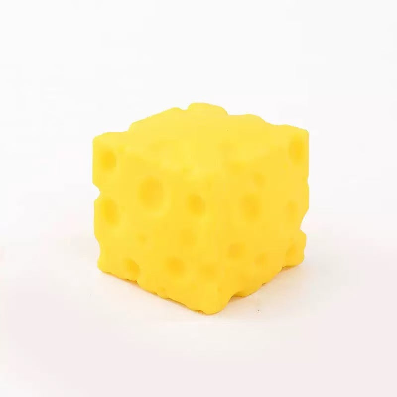 Yellow cheese block squishy toy with moulded holes on a light background