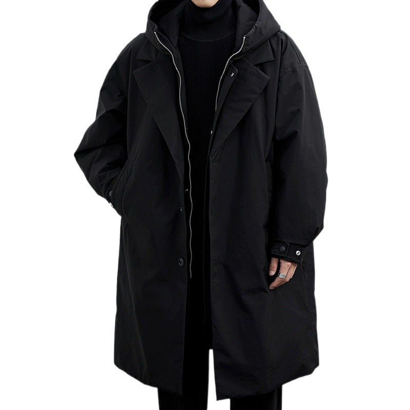 Black mid-length hooded coat with notch lapels, metal zip layer and snap cuff tab, hand in slanted pocket