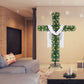 Green cross shaped Christmas tree with warm lights and a white cloth in a living room with a gray sofa