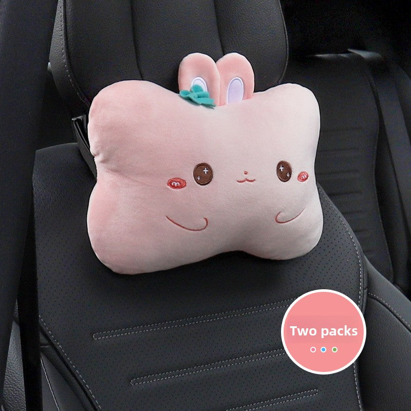 Pink rabbit cartoon headrest pillow with a teal bow on a black car seat, two pack badge
