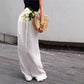 Woman in cotton linen wide leg trousers, high waist and full straight leg drape